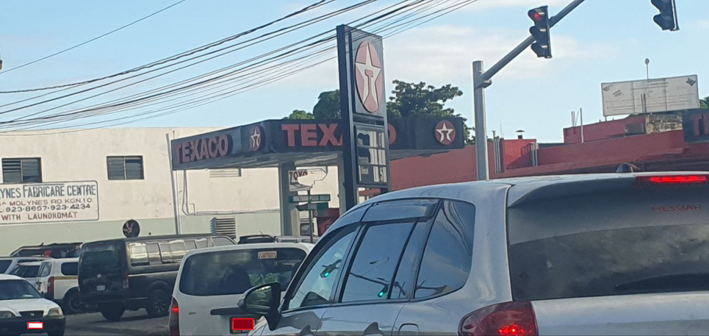 Cars at a stop light near a Texaco gas station
